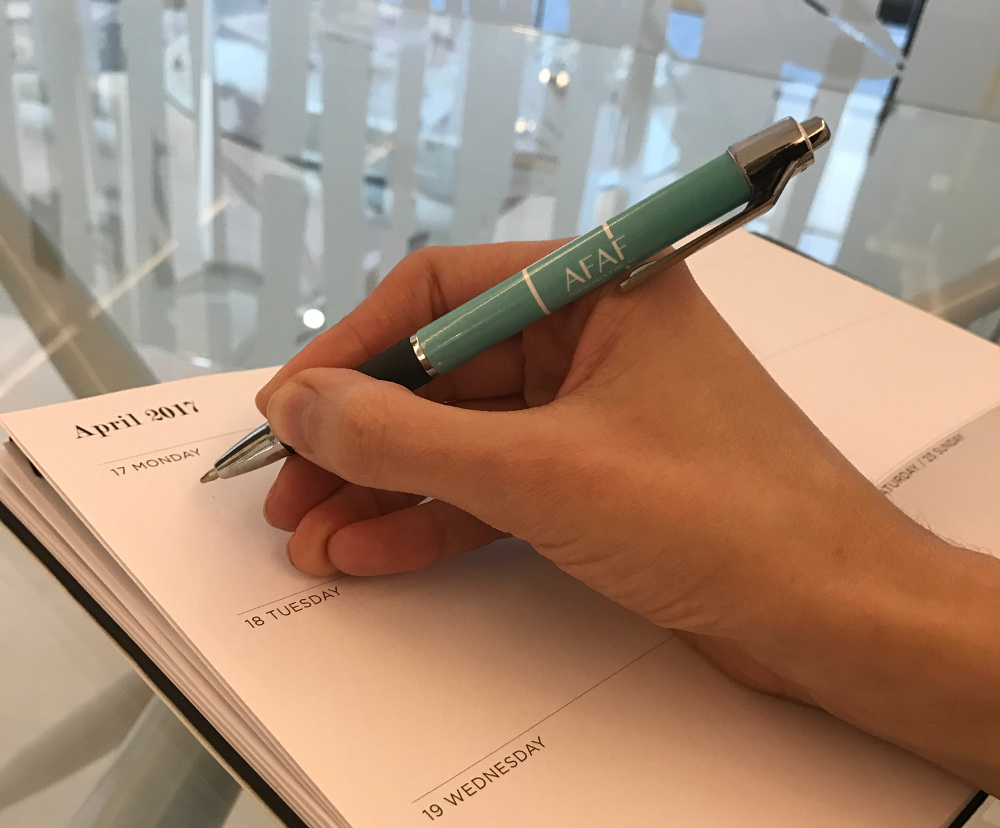 Mujer escribiendo en una agenda con bolígrafo de afaf
